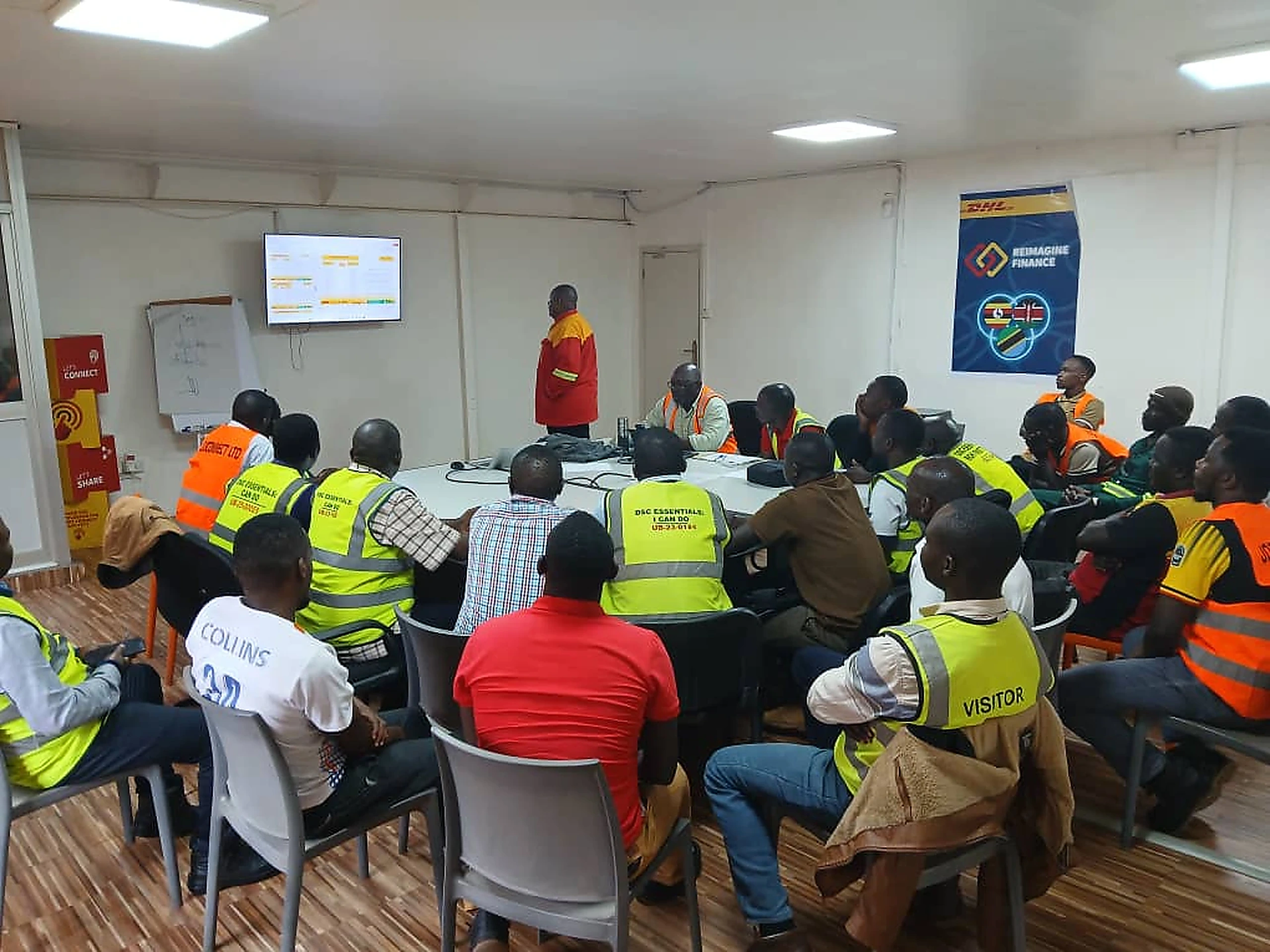 Instructor delivering a classroom road safety briefing to drivers in high-visibility vests
