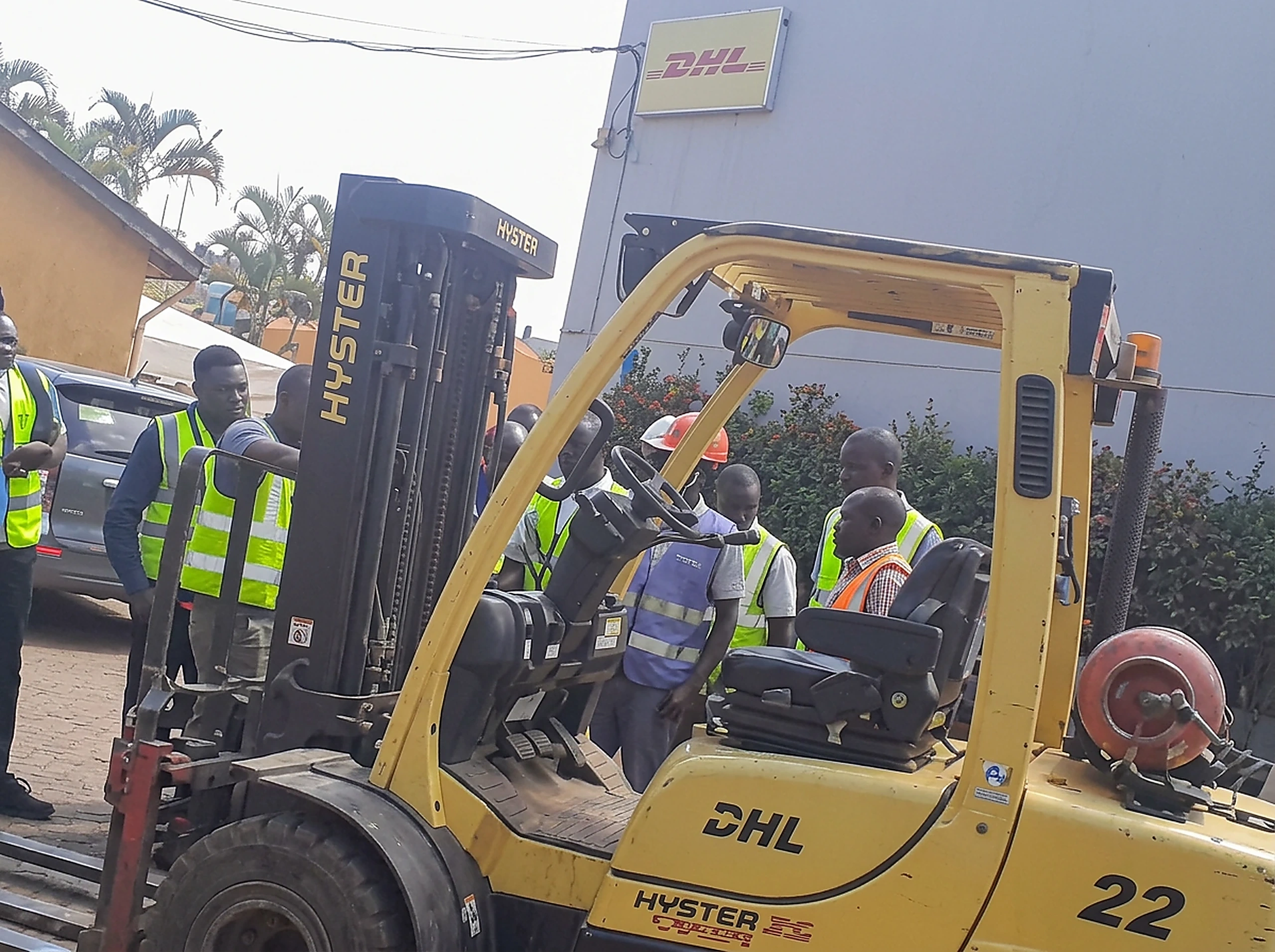 Warehouse team in high-visibility PPE receiving forklift and materials-handling safety training at a logistics site